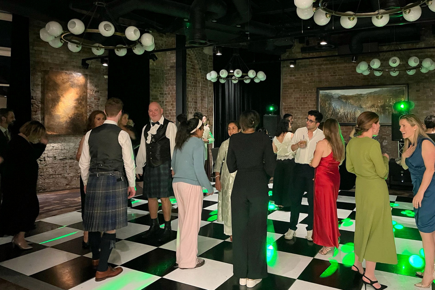 Staff on the dance floor at the autumn ball. They appear to be mostly talking rather than dancing.