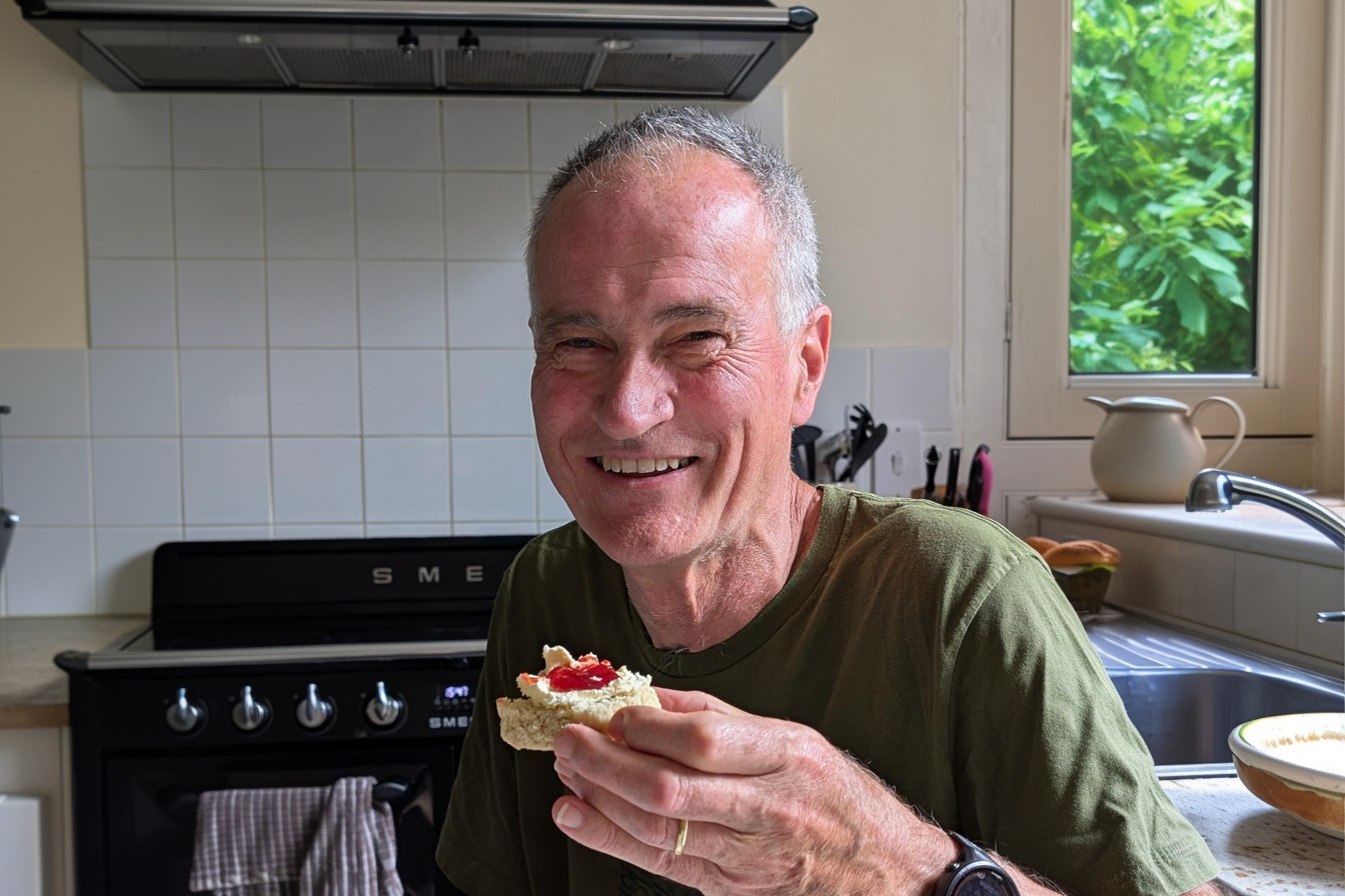 Simon St Leger-Harris 70th birthday - 1344x896px Simon St Leger-Harris enjoying a birthday scone in his kitchen